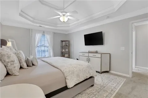 a spacious bedroom with a large bed and a flat screen tv