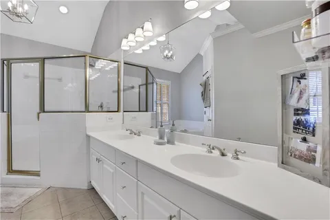 a spacious bathroom with a double vanity sink a mirror and a shower
