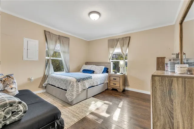 a bedroom with a bed and wooden floor