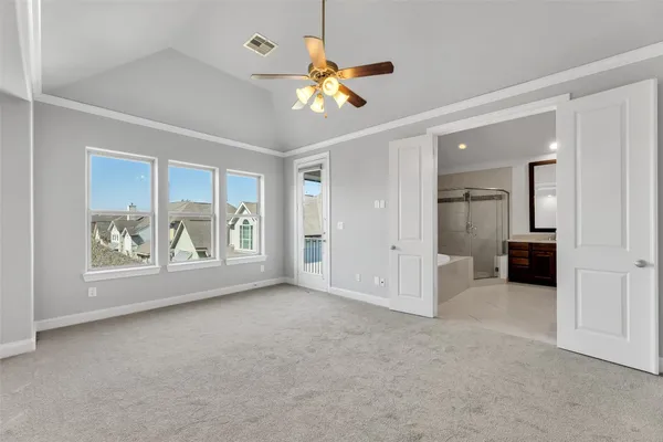 an empty room with window and a chandelier fan