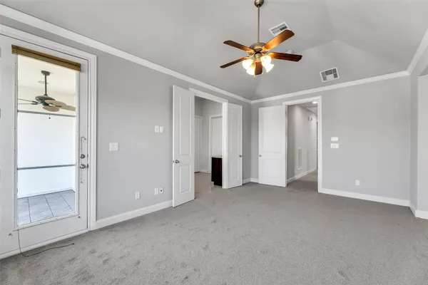a view of an empty room with window and a ceiling fan