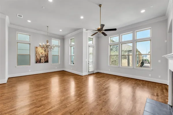 a view of an empty room with a window and wooden floor