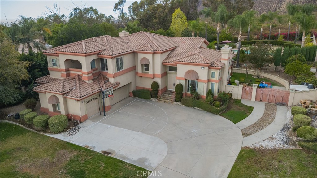 a view of a white house with a yard plants and large tree
