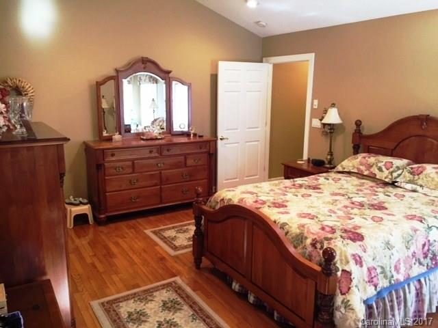 61 Bowman Ridge Road, Unit 5 Hendersonville, NC 28739 - Photo 14 of 24 a bedroom with a bed and a mirror on dresser