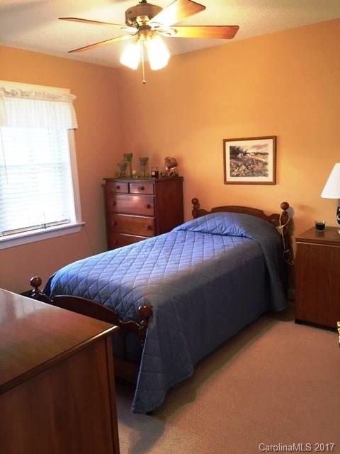 61 Bowman Ridge Road, Unit 5 Hendersonville, NC 28739 - Photo 17 of 24 a bedroom with a bed and a chandelier