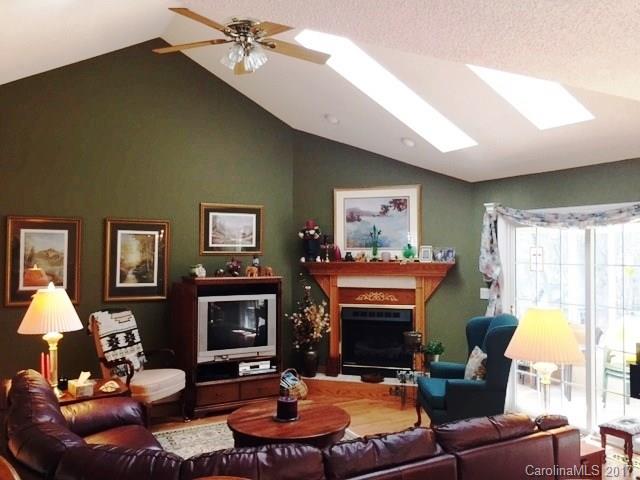 61 Bowman Ridge Road, Unit 5 Hendersonville, NC 28739 - Photo 5 of 24 a living room with furniture a fireplace and a large window