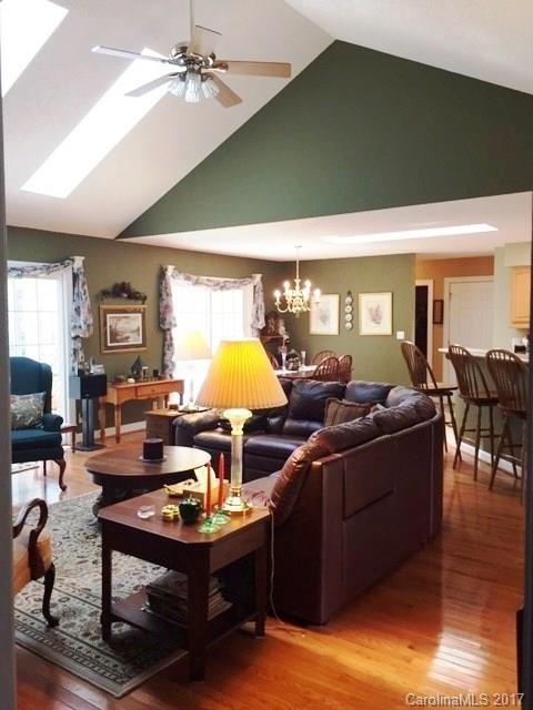 61 Bowman Ridge Road, Unit 5 Hendersonville, NC 28739 - Photo 6 of 24 a living room with furniture a chandelier and a wooden floor