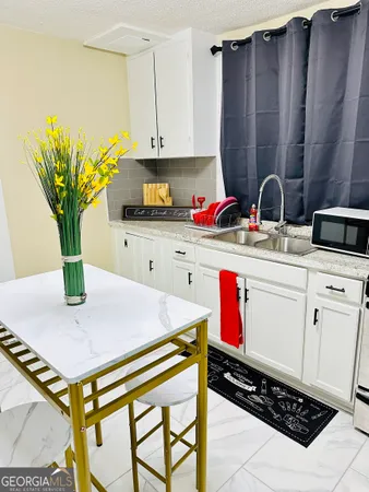 a kitchen with stainless steel appliances kitchen island granite countertop a sink a stove and white cabinets