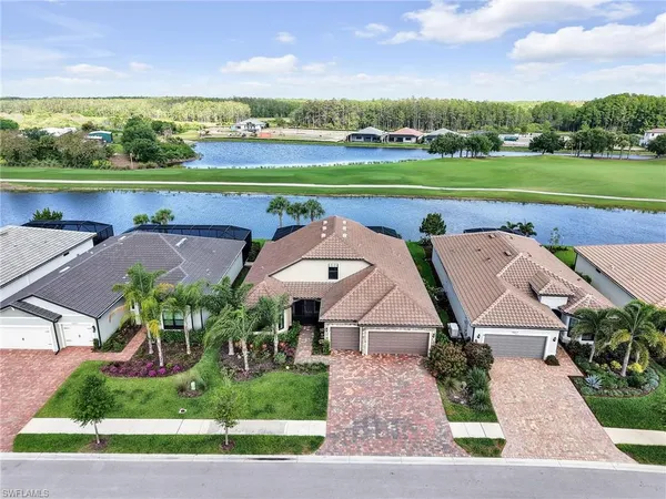 an aerial view of a house with big yard and large trees