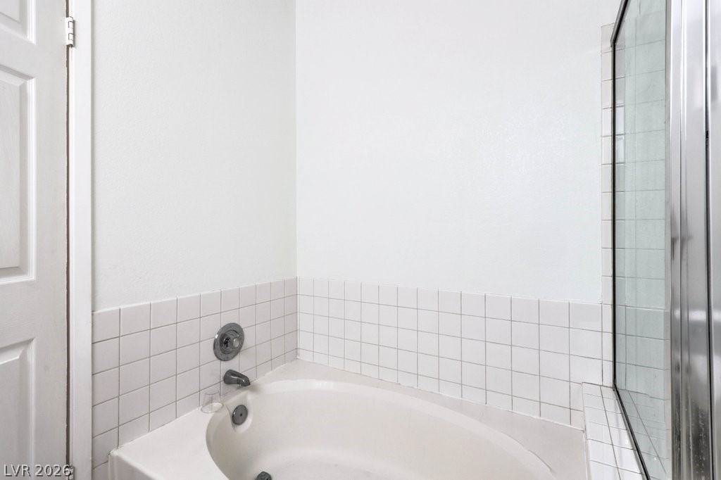 2201 Ramsgate Drive, Unit 1017 Henderson, NV 89074 - Photo 17 of 30 This serene bathroom offers a pristine tub and shower for ultimate relaxation.