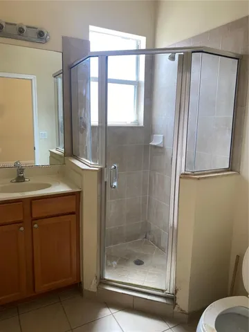 a bathroom with a shower a sink and a mirror