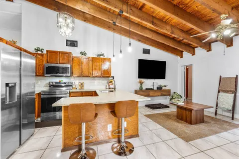 a kitchen with stainless steel appliances kitchen island granite countertop a sink and a refrigerator