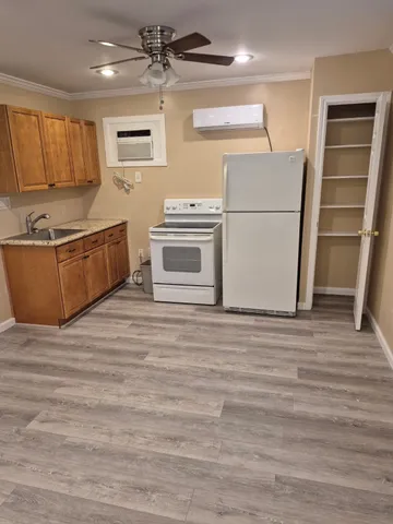 a kitchen with granite countertop a refrigerator and a stove top oven