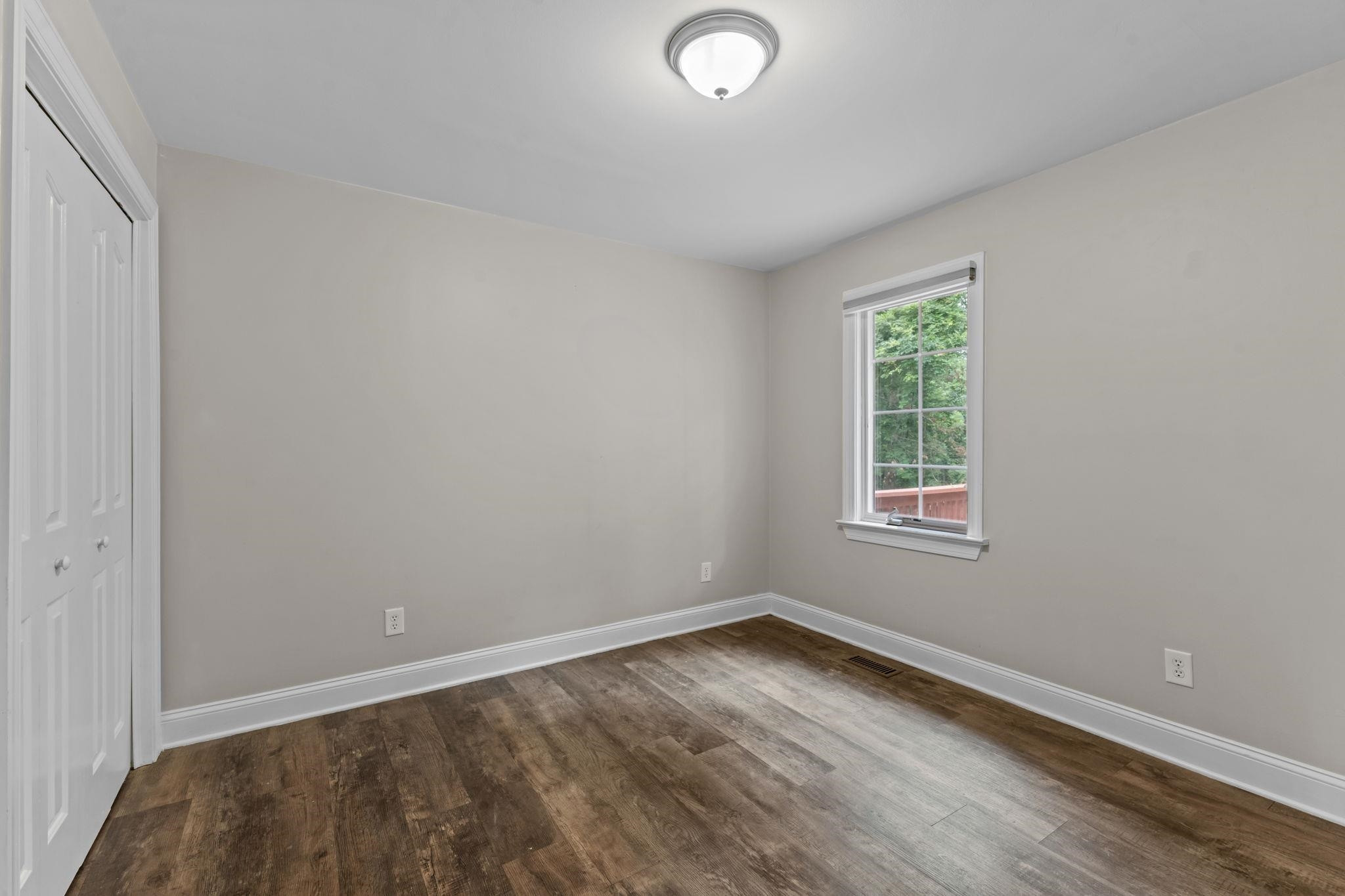 409 Husketh Road Youngsville, NC 27596 - Photo 18 of 29 an empty room with wooden floor and windows