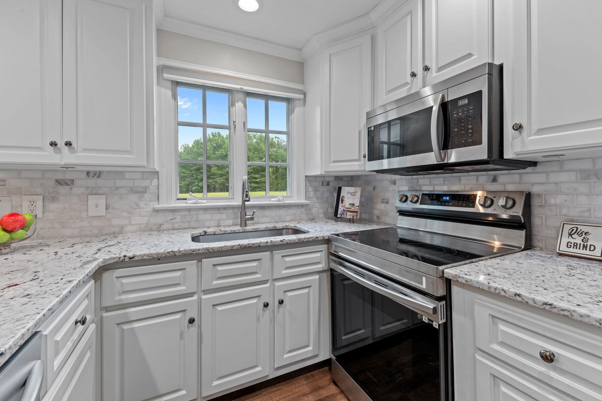 409 Husketh Road Youngsville, NC 27596 - Photo 10 of 29 a kitchen with stainless steel appliances granite countertop white cabinets granite counter tops and a window