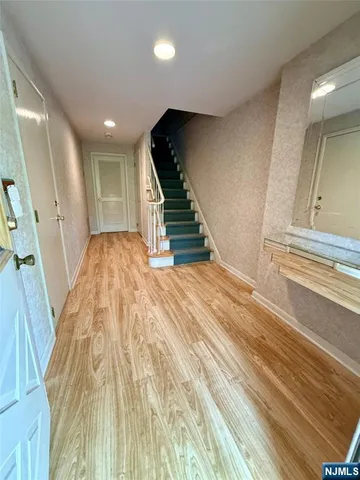 a view of a hallway with stairs and a living room view