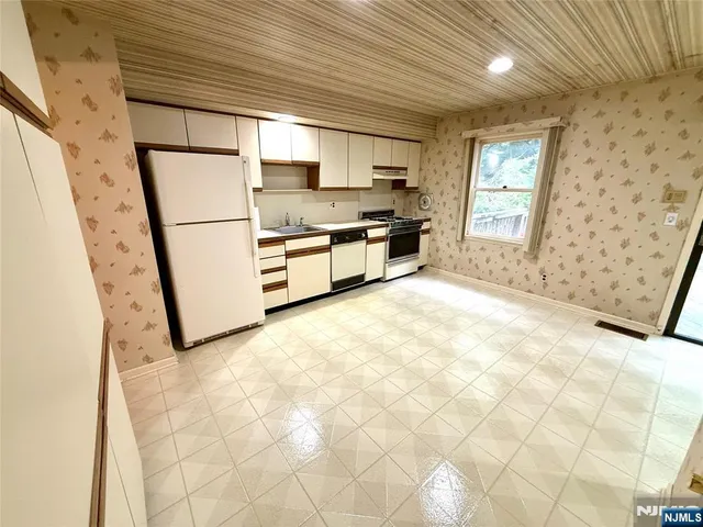a kitchen with stainless steel appliances a refrigerator sink and cabinets