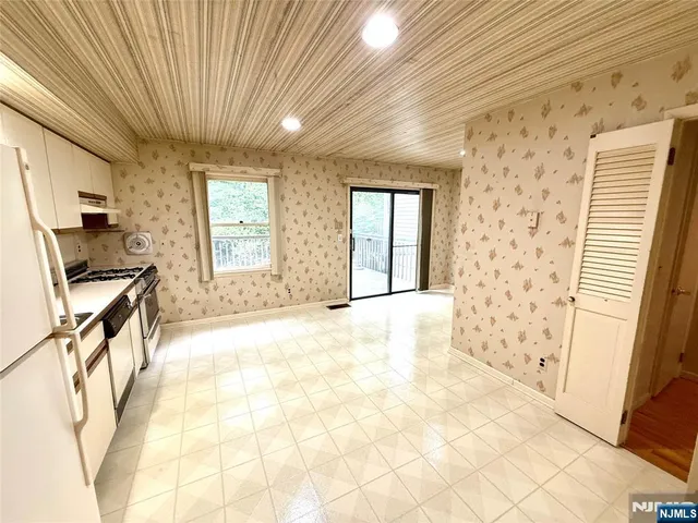 a view of a hallway to a room with windows