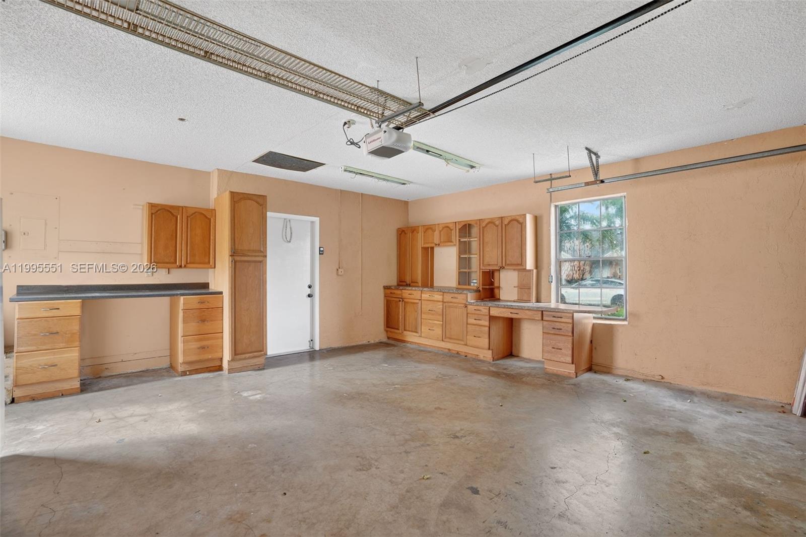 14722 Southwest 110th Terrace Miami, FL 33196 - Photo 32 of 37 a view of a room with cabinet a ceiling fan and windows