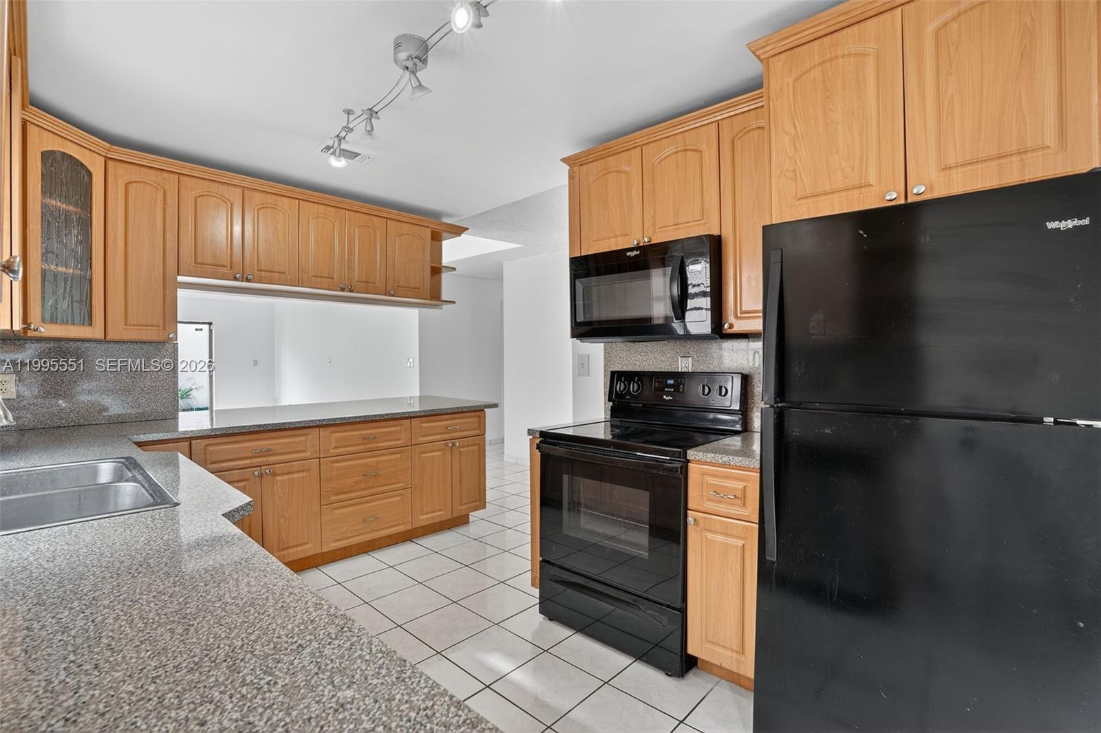 14722 Southwest 110th Terrace Miami, FL 33196 - Photo 9 of 37 a kitchen with stainless steel appliances granite countertop a refrigerator a stove and a sink with wooden cabinets
