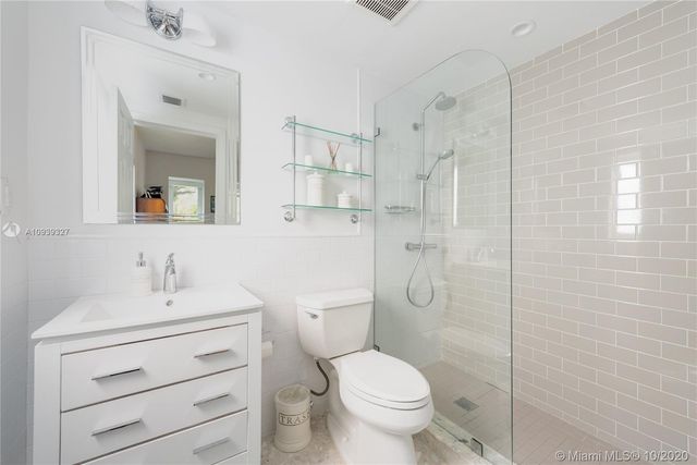 a bathroom with a toilet sink vanity and shower