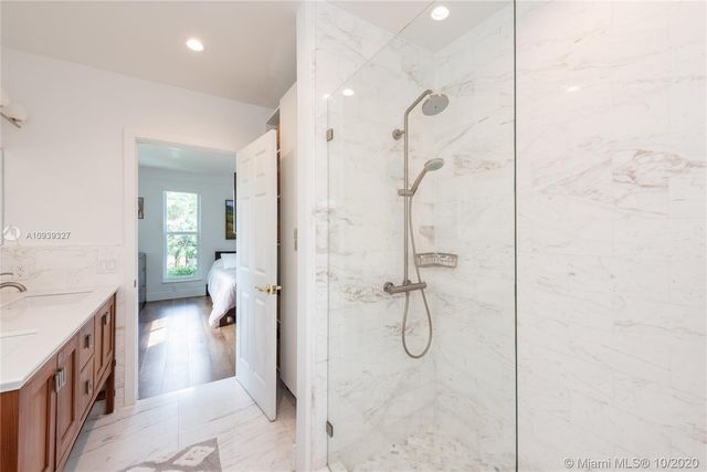 a bathroom with a granite countertop sink a toilet and shower