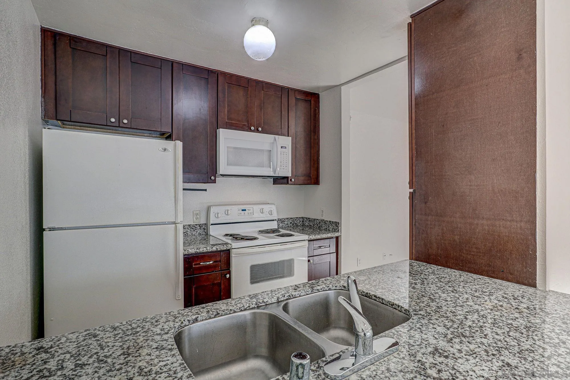 6902 Mission Gorge Road San Diego, CA 92120 - Photo 7 of 14 a kitchen with stainless steel appliances granite countertop a refrigerator a stove a sink and a microwave