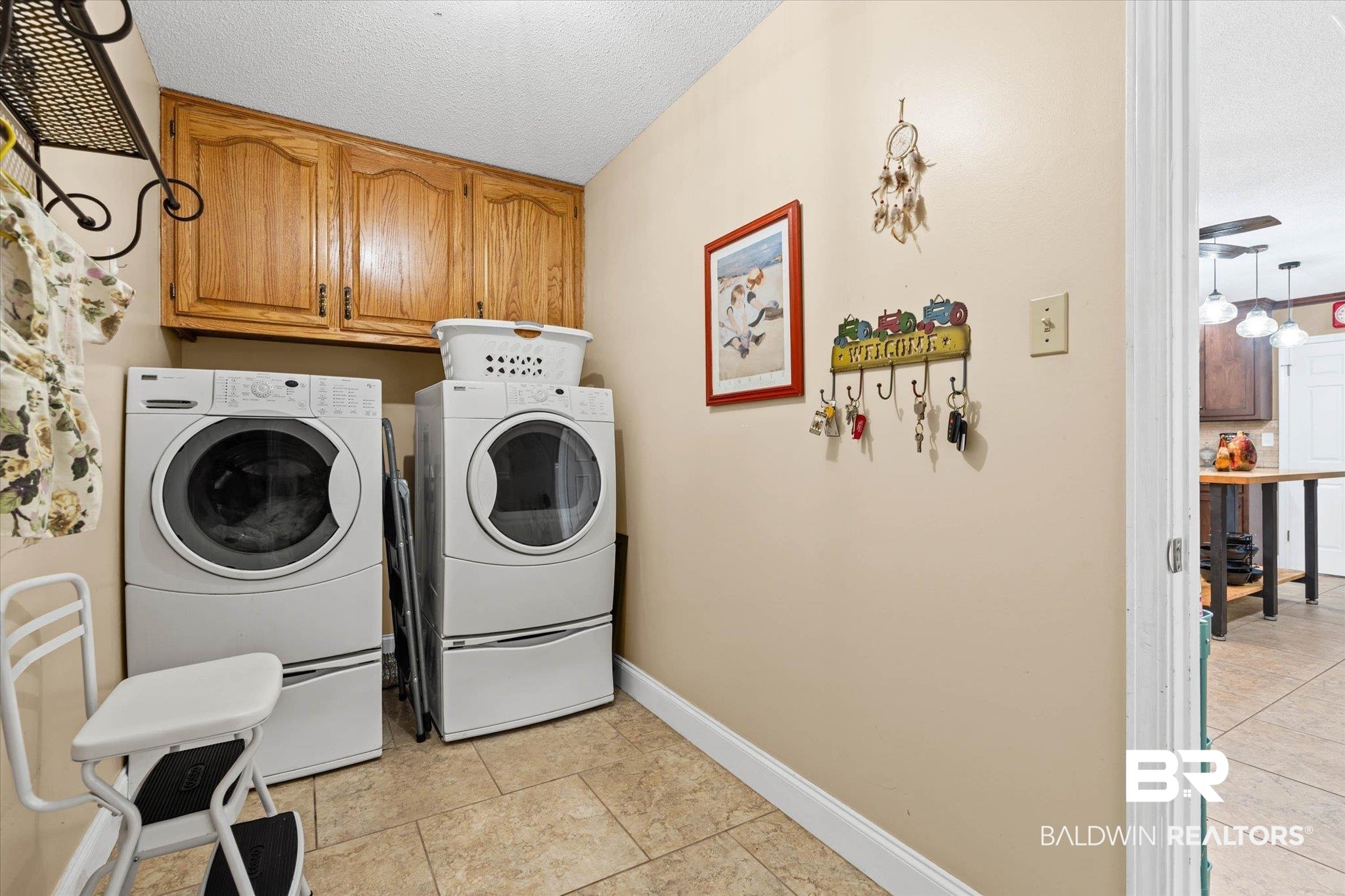 7410 Smithfield Road East Mobile, AL 36695 - Photo 18 of 24 Dedicated laundry area featuring upper wood cabinetry and neutral tile flooring