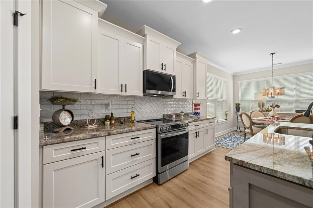 6834 Midway Road Pelzer, SC 29669 - Photo 11 of 50 This modern kitchen features elegant countertops, abundant cabinetry, and an adjoining dining area.
