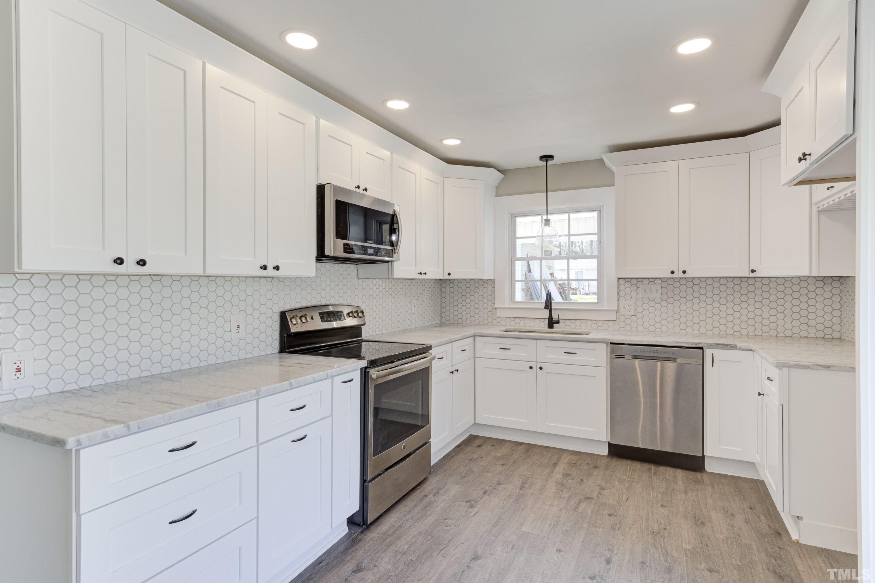 5809 Neuse Street Raleigh, NC 27610 - Photo 4 of 19 a kitchen with granite countertop white cabinets white stainless steel appliances and sink