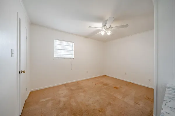 an empty room with a window and a fan