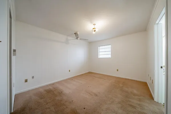 an empty room with windows and ceiling fan