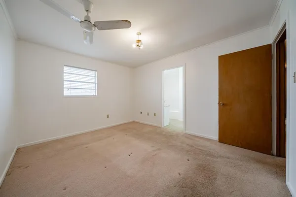 an empty room with windows and ceiling fan