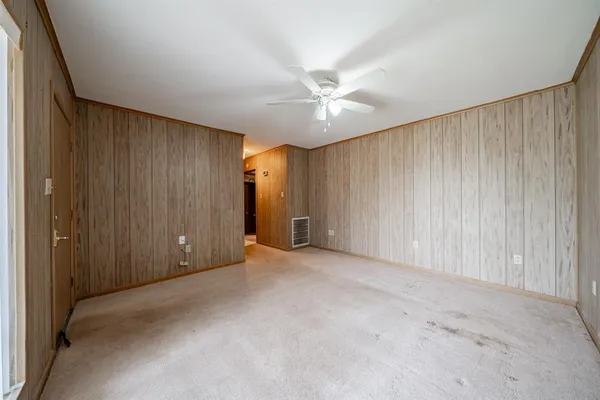 an empty room with fan and windows