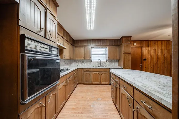 a kitchen with granite countertop cabinets stainless steel appliances a sink and wooden floor