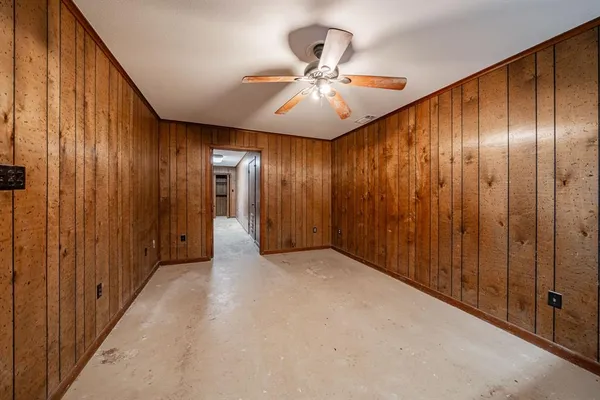 an empty room with chandelier fan