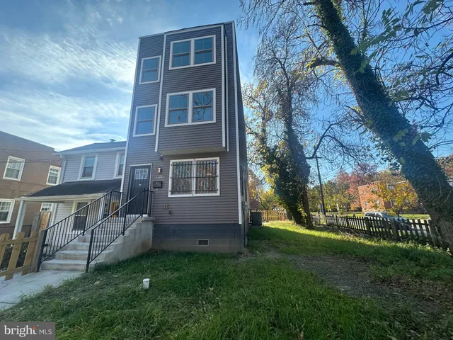 a view of backyard of house with outdoor seating and green space