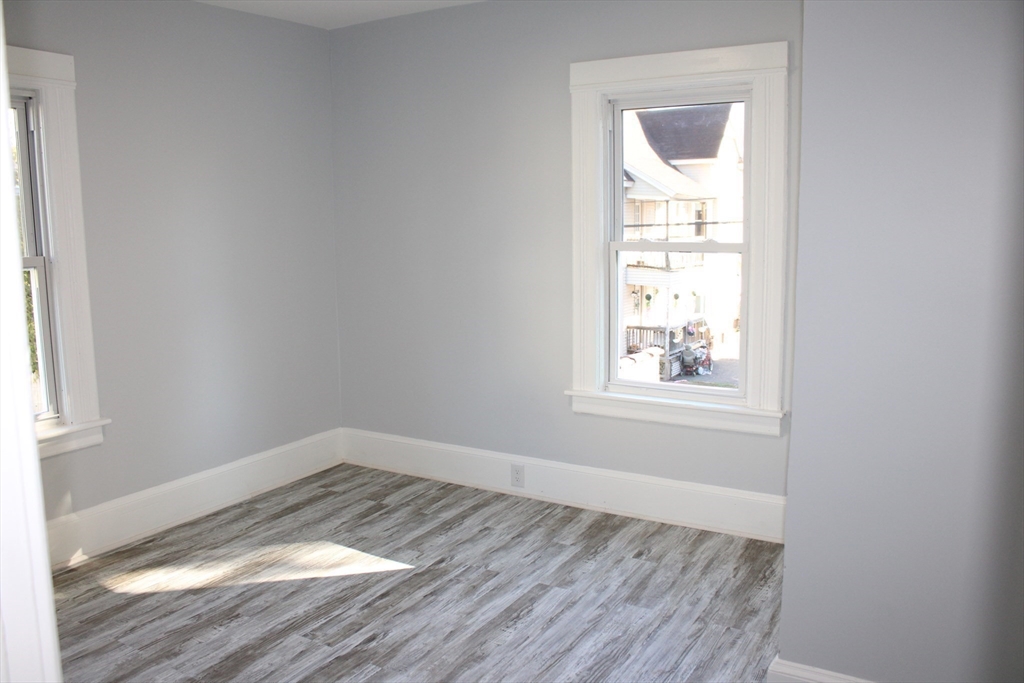 25 Malden Street Springfield, MA 01108 - Photo 23 of 25 an empty room with wooden floor and windows