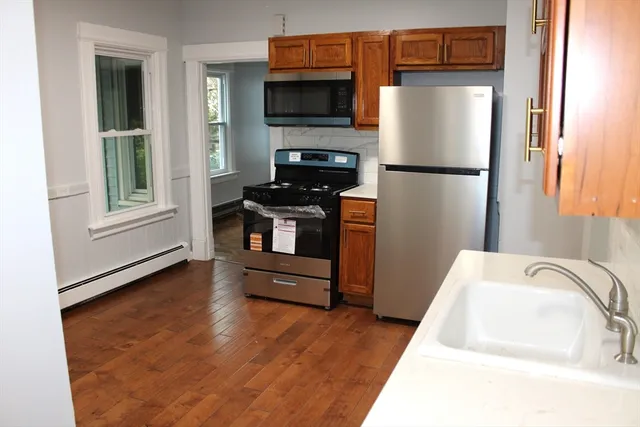 a kitchen with granite countertop a refrigerator and a stove top oven