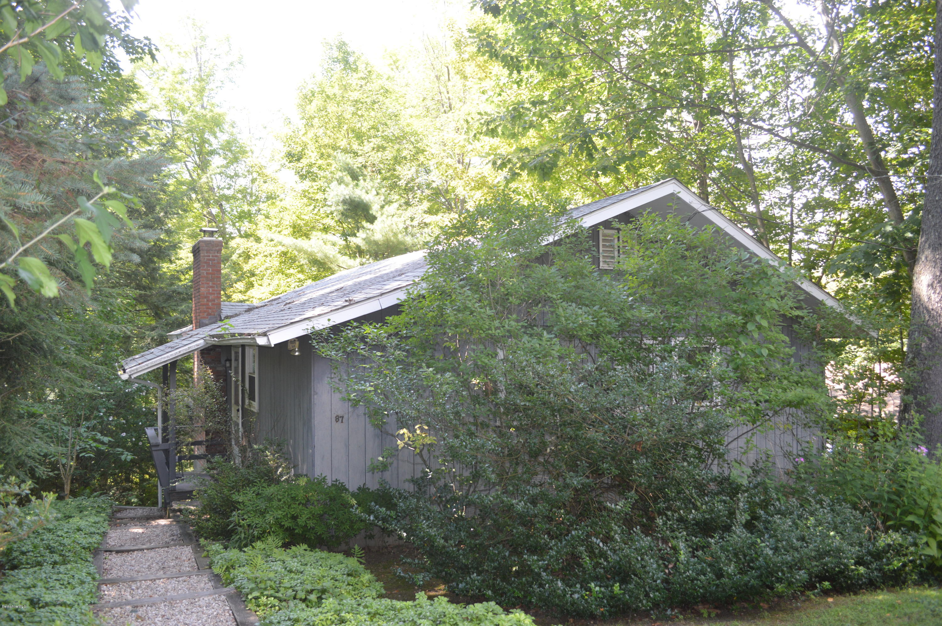 87 Lake Road Richmond, MA 01201 - Photo 1 of 3 a backyard of a house with plants and large trees