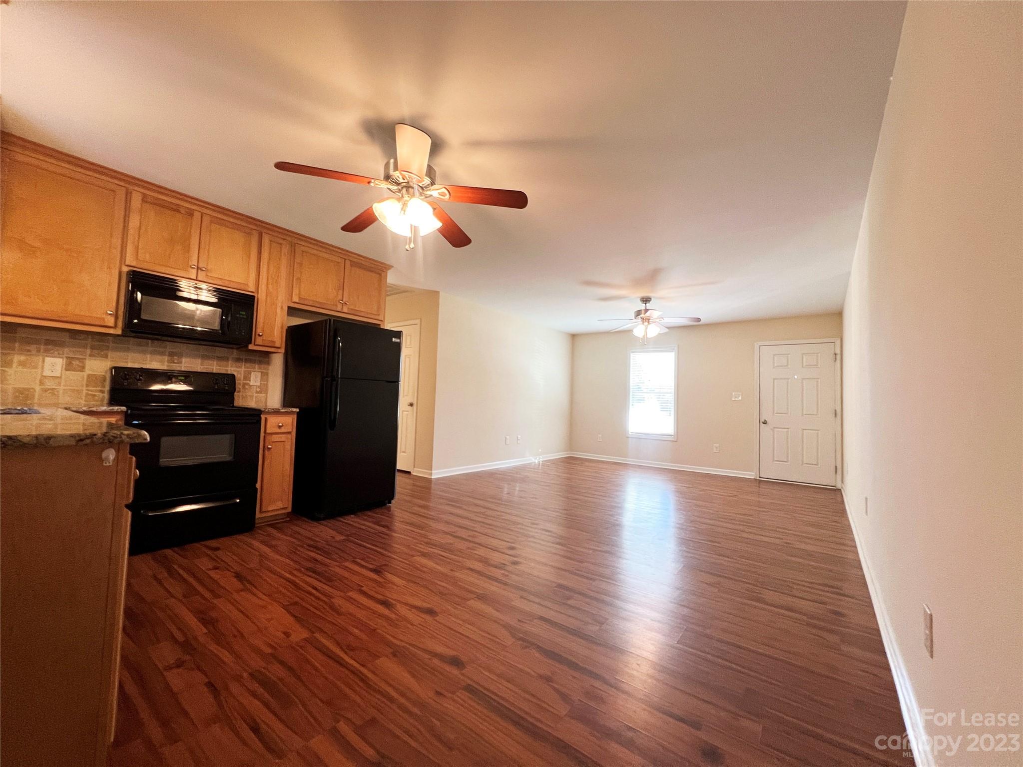 3835 Lee Moore Road Maiden, NC 28650 - Photo 5 of 16 a kitchen with stainless steel appliances granite countertop a refrigerator a stove top oven a sink and dishwasher with wooden floor