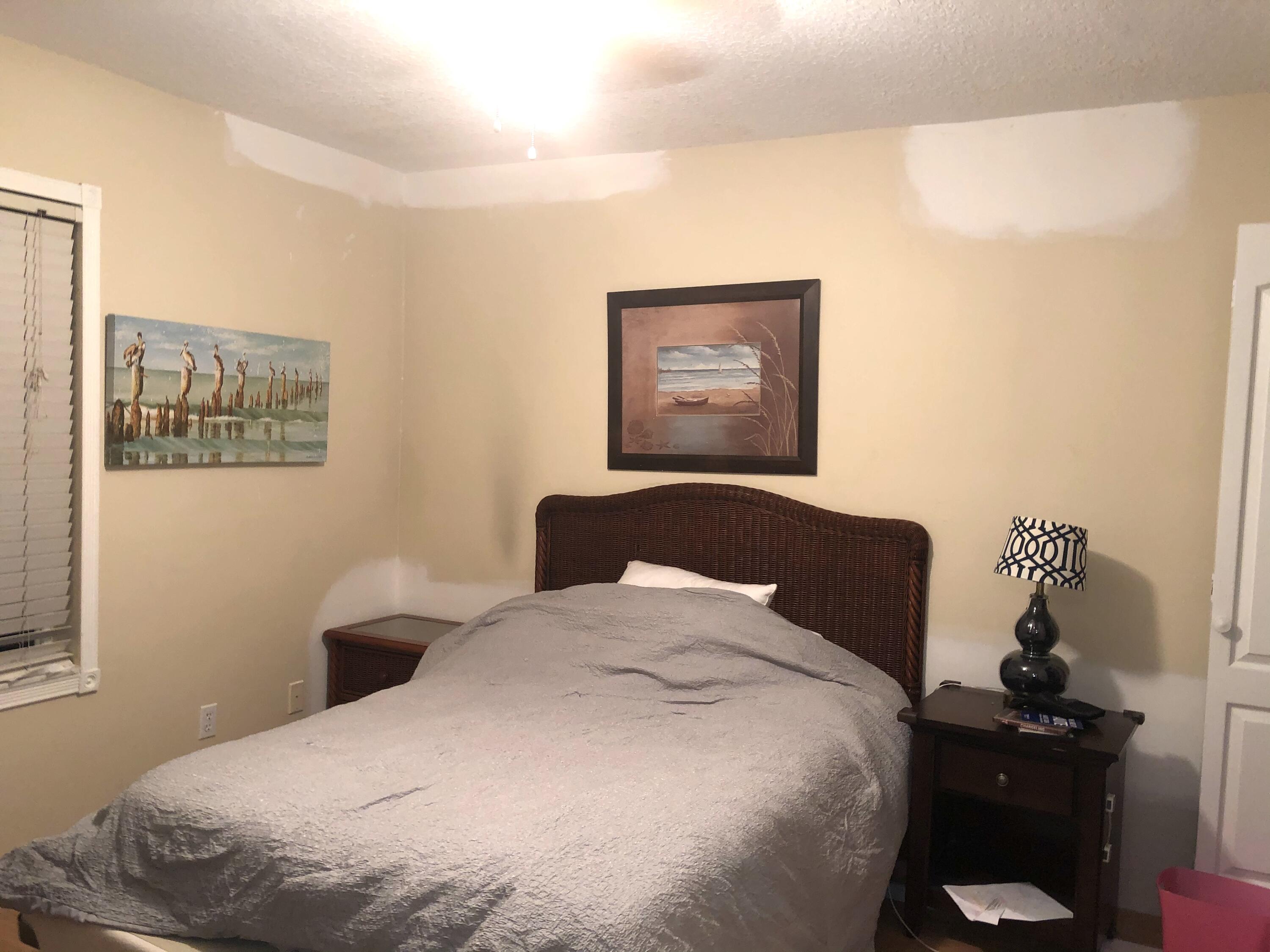 12136 88th Place North West Palm Beach, FL 33412 - Photo 11 of 29 a bedroom with a bed and a lamp on dresser
