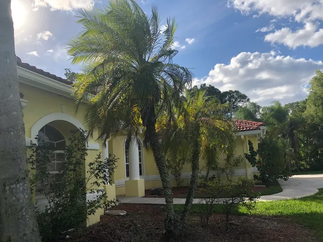 a view of a fountain in front of a house with a big yard