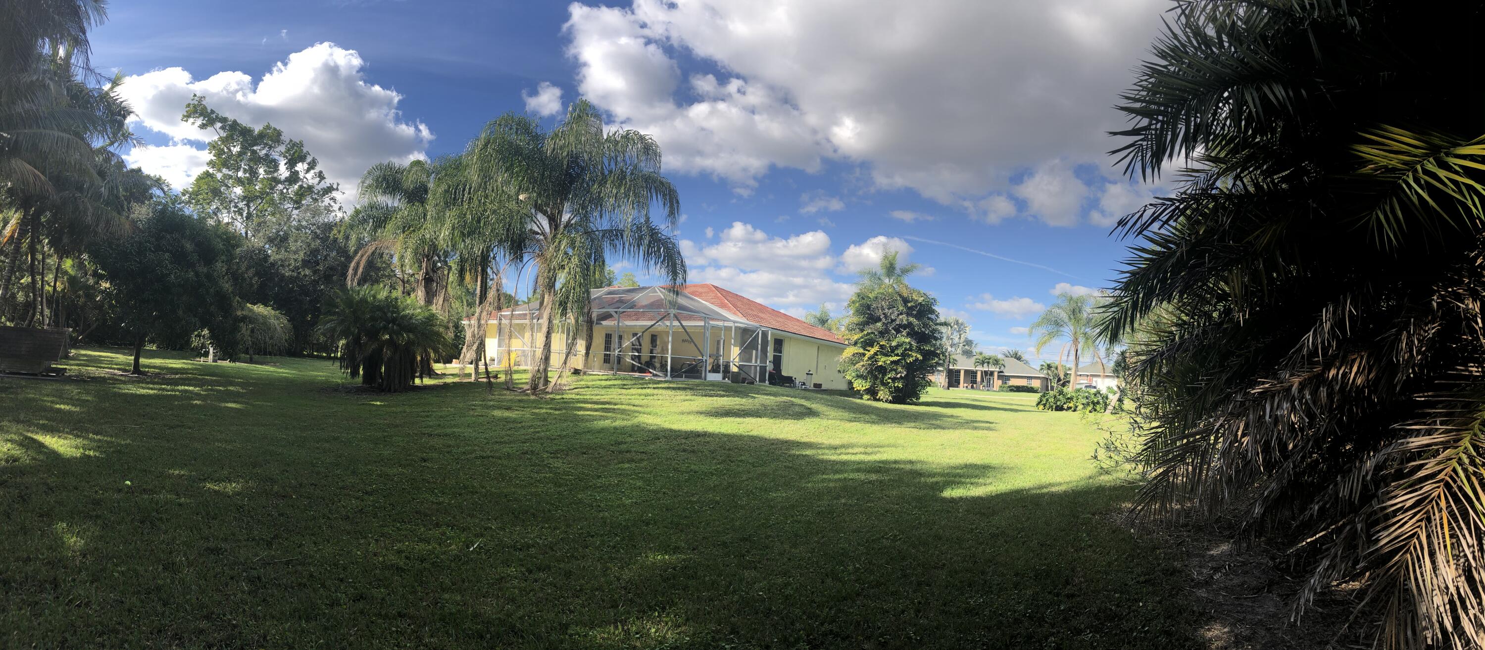 12136 88th Place North West Palm Beach, FL 33412 - Photo 23 of 29 a view of a fountain in front of a house with a big yard