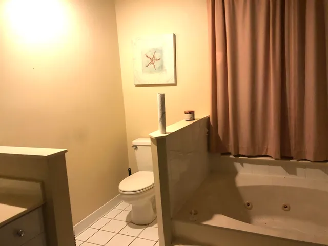 a bathroom with a toilet a sink and mirror