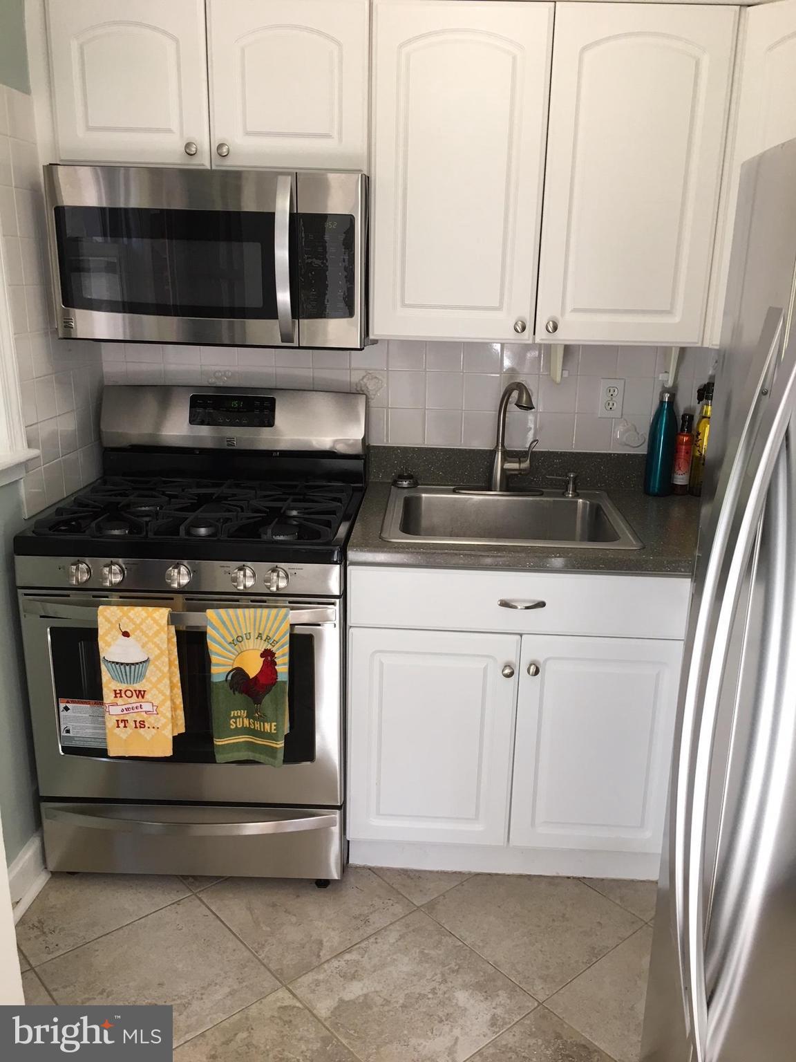 511 Mansfield Road Silver Spring, MD 20910 - Photo 12 of 29 a kitchen with stainless steel appliances granite countertop white cabinets and a stove a oven with white countertops