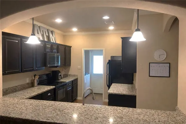 a kitchen with stainless steel appliances granite countertop a refrigerator a oven and a sink with granite countertops