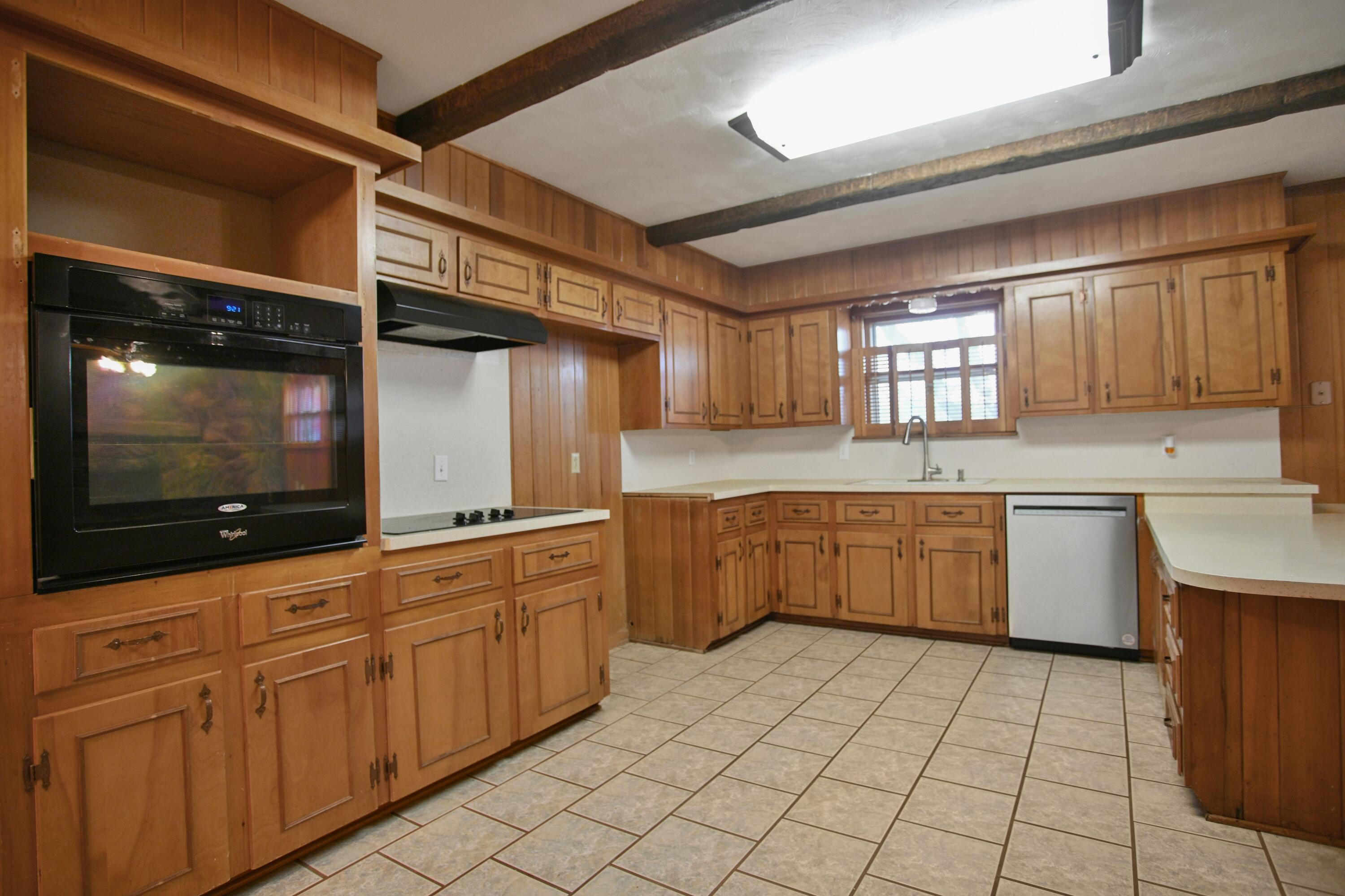 5420 8th Street Lubbock, TX 79416 - Photo 14 of 35 a kitchen with granite countertop a sink a stove top oven and cabinets