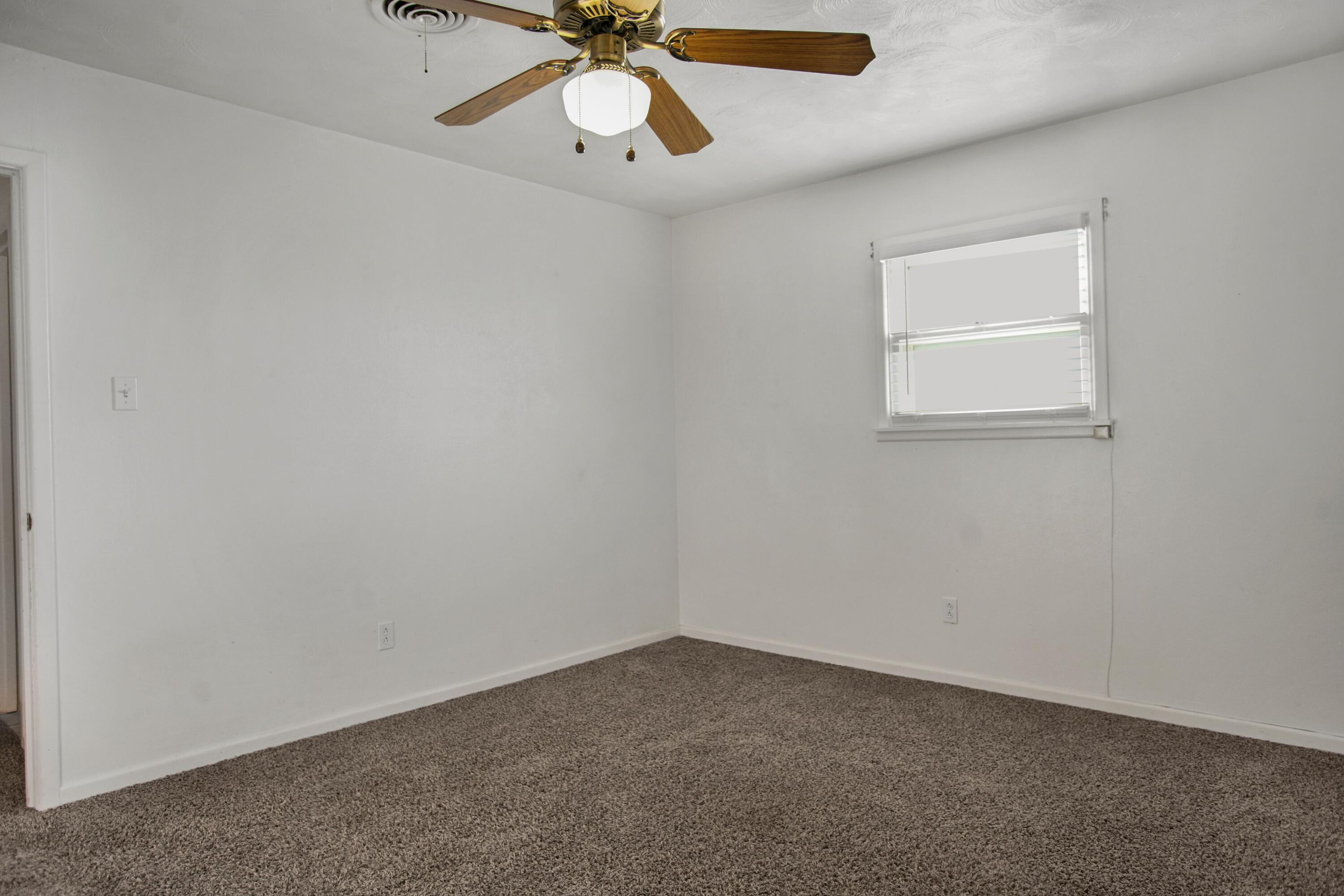 5420 8th Street Lubbock, TX 79416 - Photo 21 of 35 an empty room with a window and a fan
