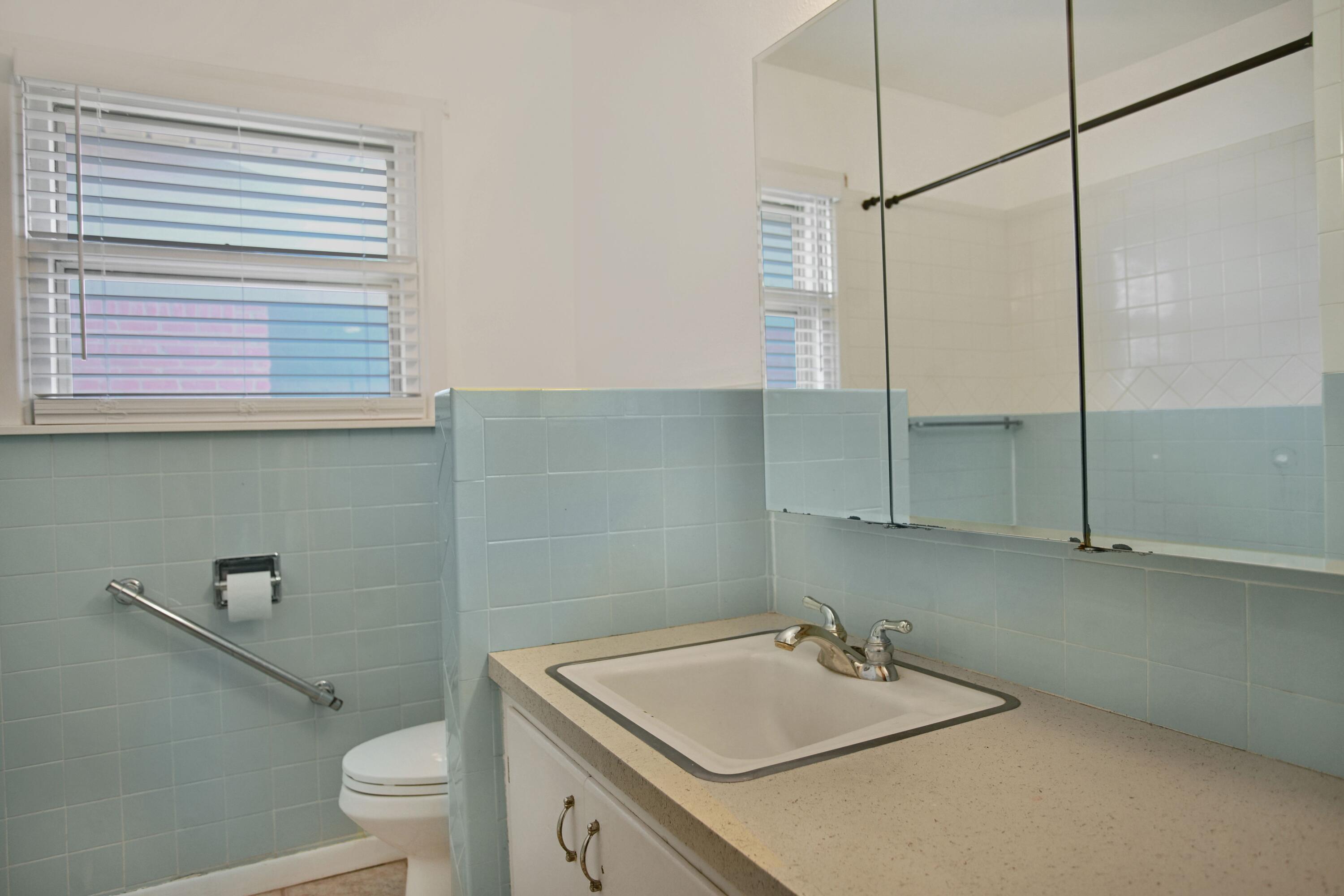 5420 8th Street Lubbock, TX 79416 - Photo 22 of 35 a bathroom with a sink a toilet and a mirror